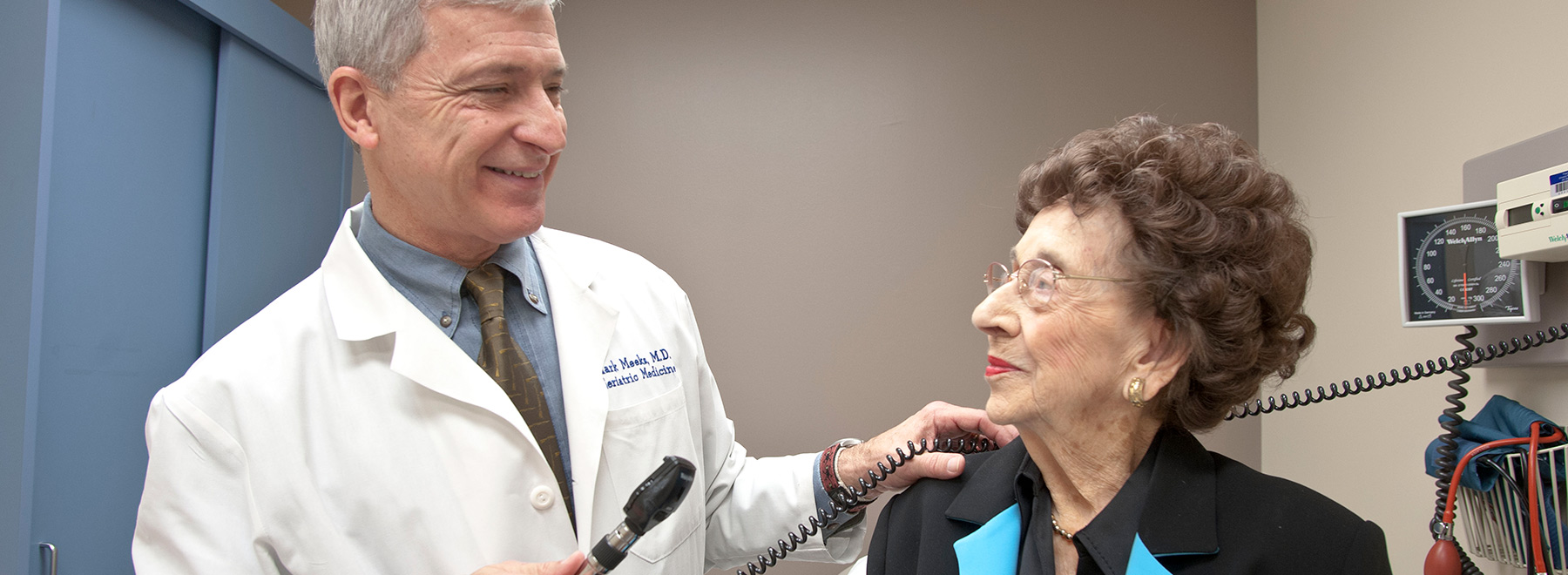 A doctor examining a geriatric patient with an otoscope. A doctor examining a geriatric patient with an otoscope.